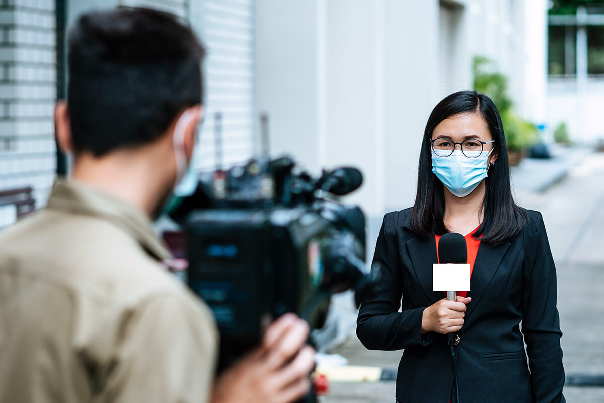 Media spokesperson wears mask during interview