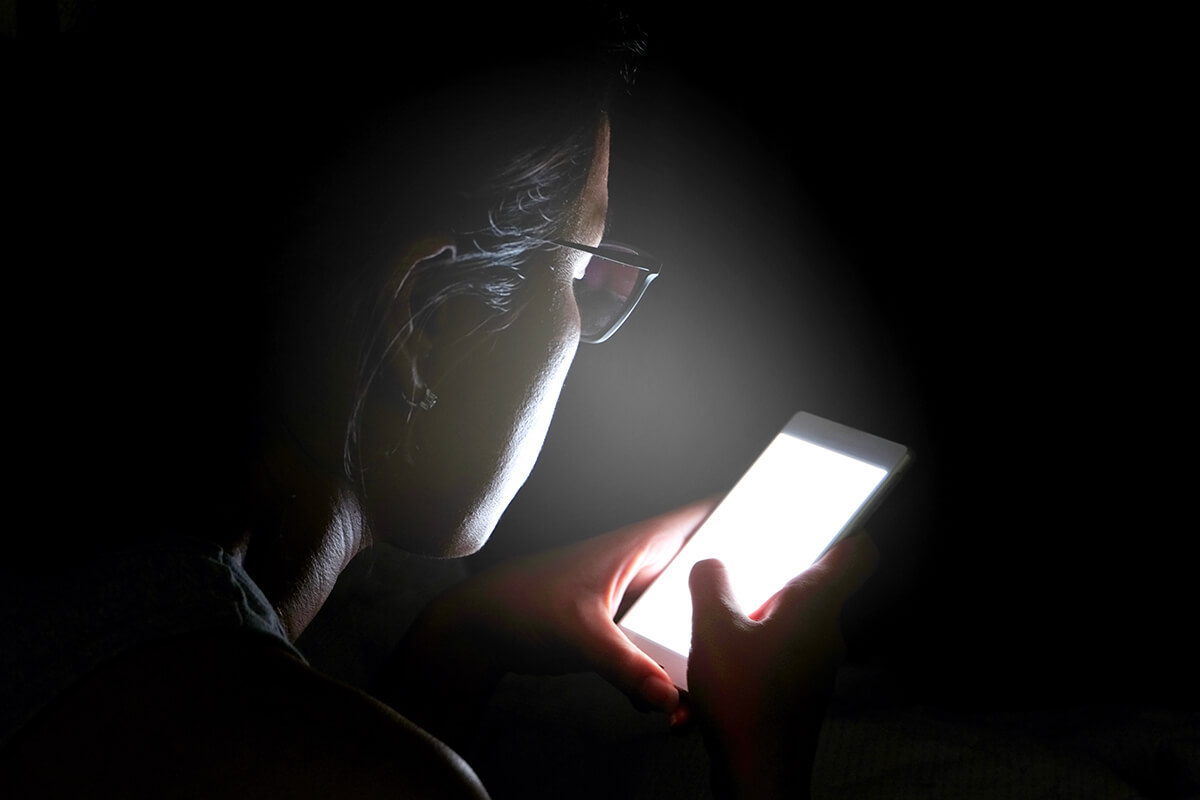 Person looking at phone screen in the dark