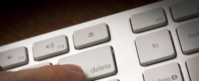 Finger pressing delete on a keyboard