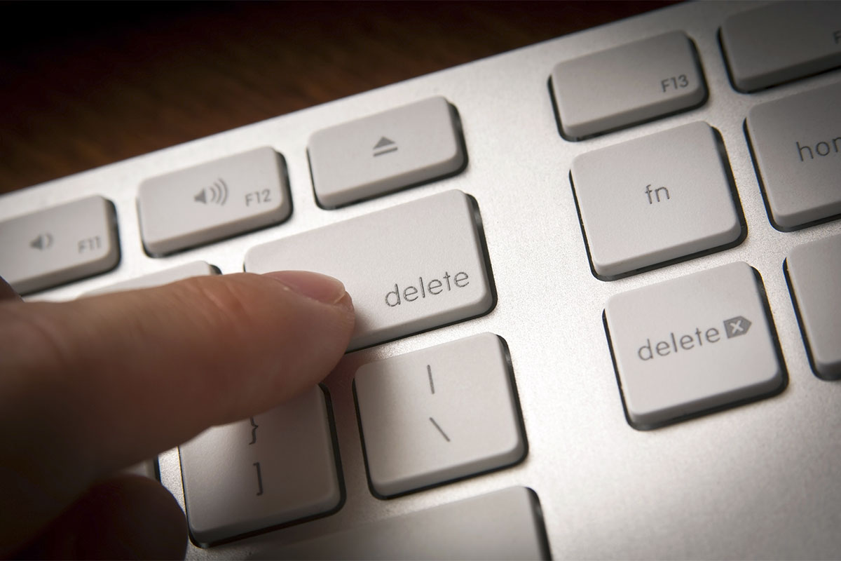 Finger pressing delete on a keyboard