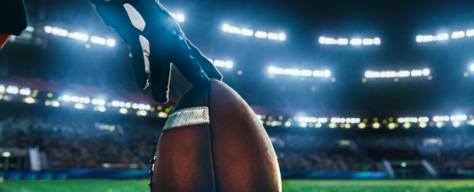 Football on field in a lit stadium at night