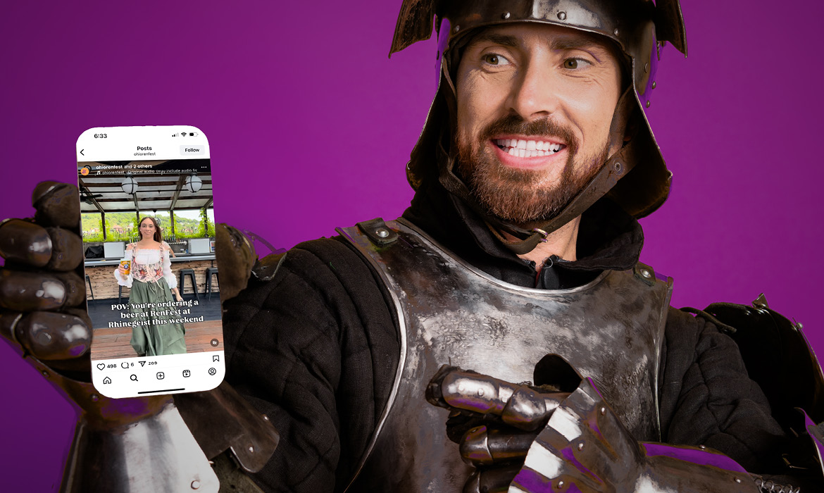 A man dressed as a knight holds up a phone featuring an ORF social media post.